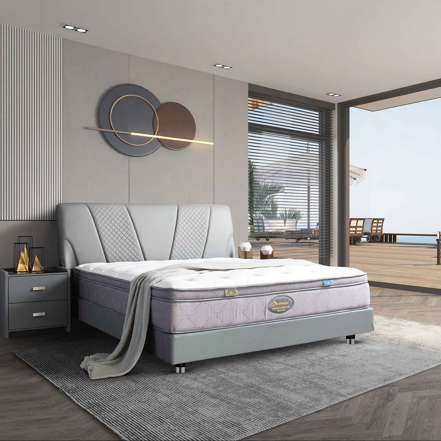 Stylish bedroom with gray upholstered bed frame and comfortable mattress in a modern setting overlooking a patio and ocean, featuring contemporary wall art and nightstand.