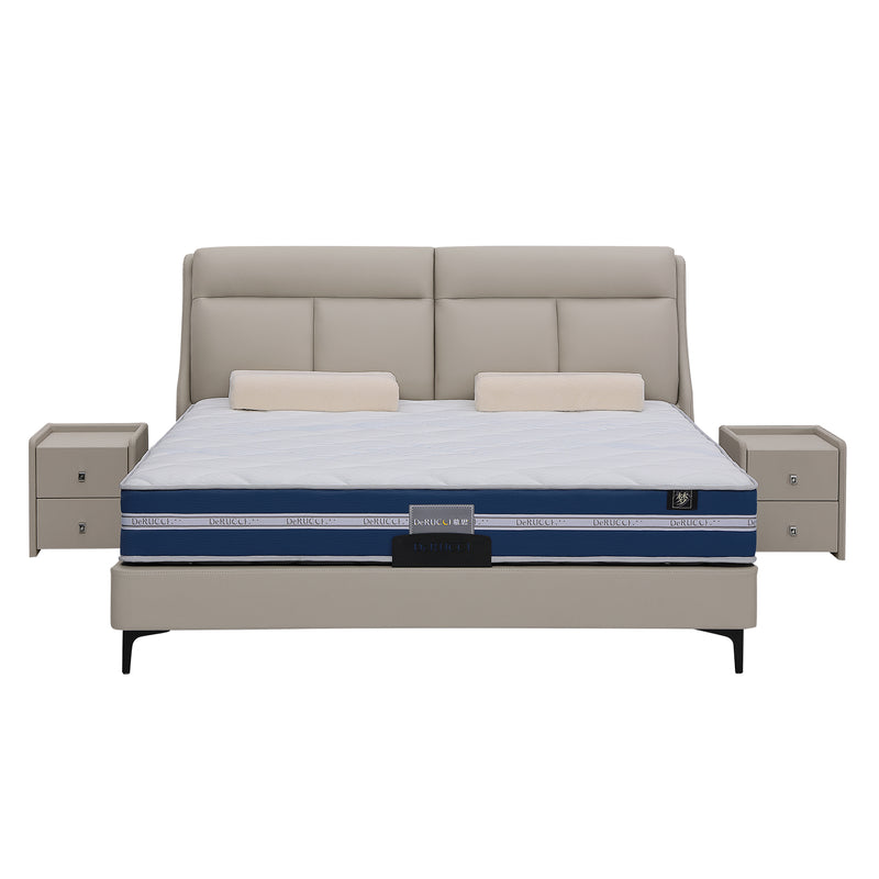 Sleek grey leather bed frame with upholstered headboard, blue and white patterned mattress, beige cushions, and matching bedside tables