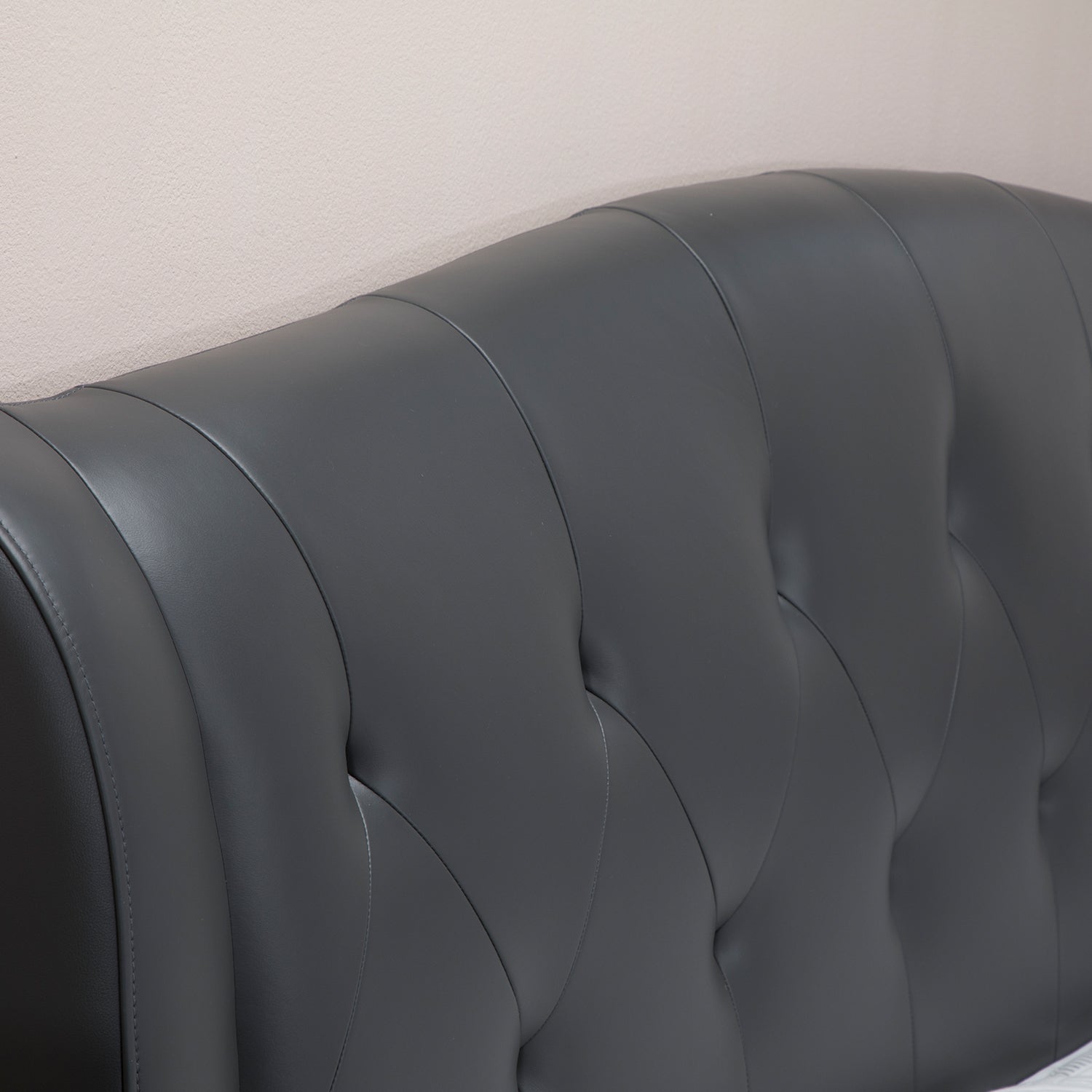Dark gray leather upholstered bed frame backrest with a tufted design, showcasing a sleek and contemporary look