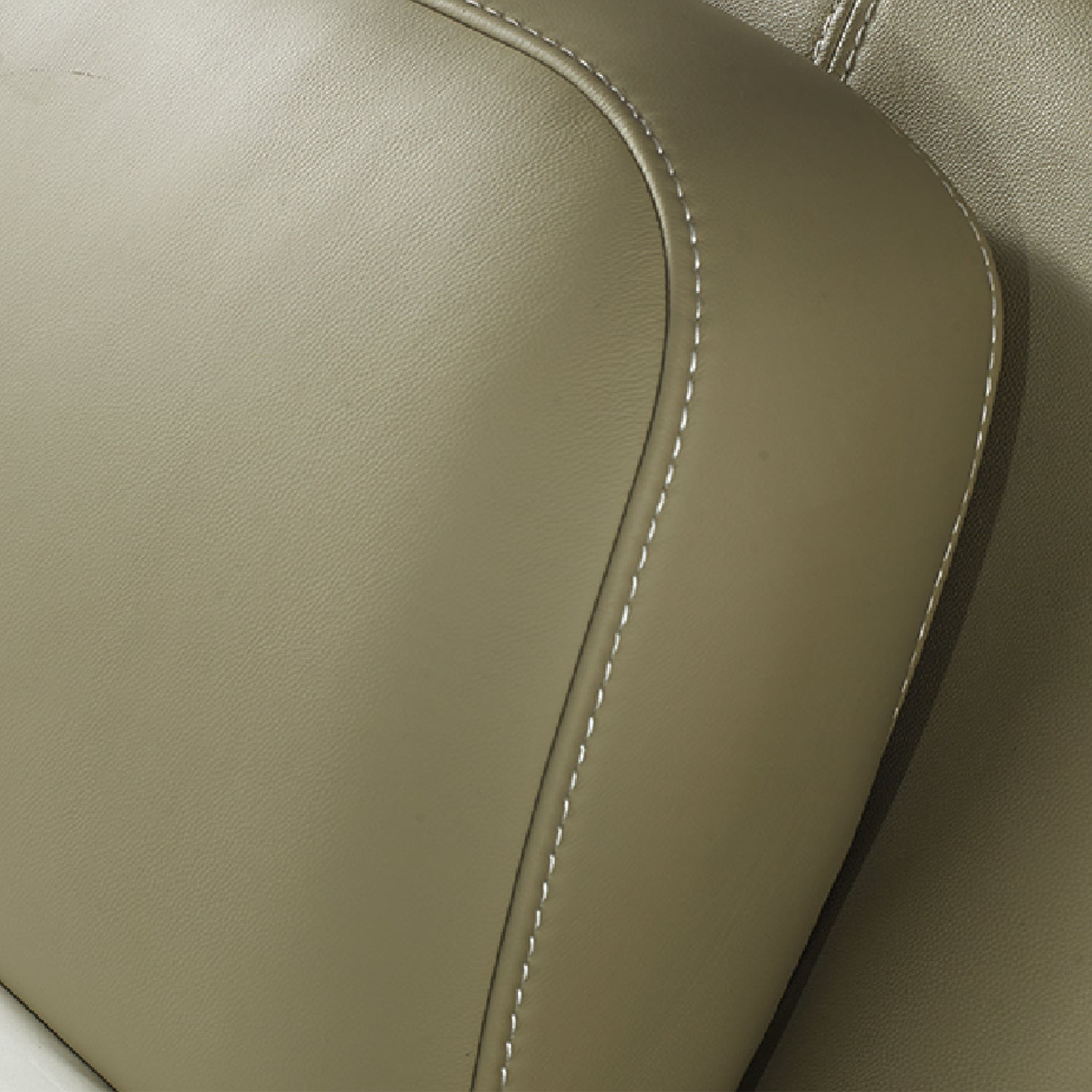 Close-up of beige leather bed frame headboard with detailed stitching, showcasing high-quality craftsmanship in DeRUCCI's bedroom furniture.