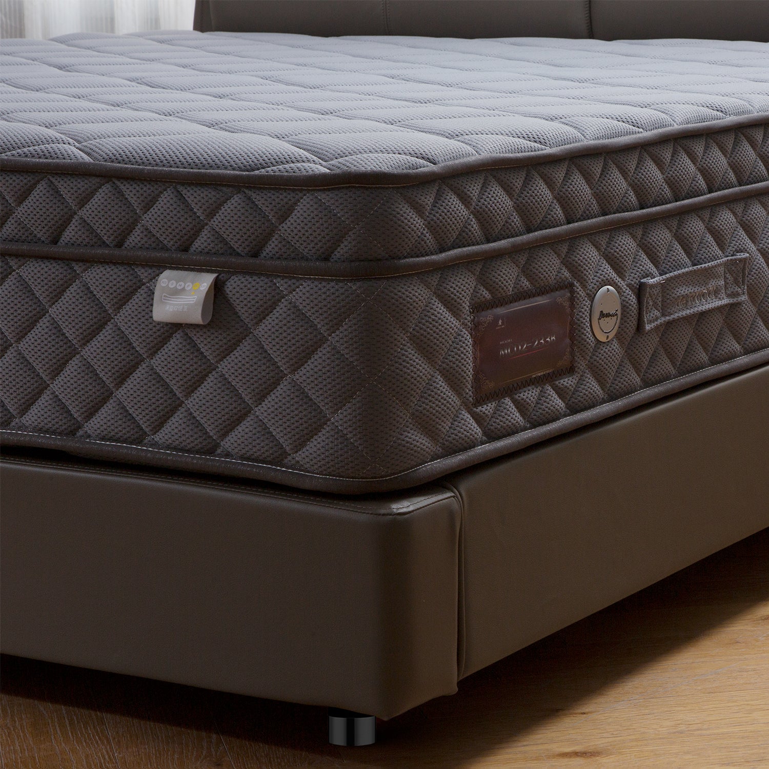 Close-up of DeRUCCI bed frame BZZ4 - 243 featuring a quilted grey mattress with various tags and labels, and a dark brown upholstered bed frame with a minimalist design.