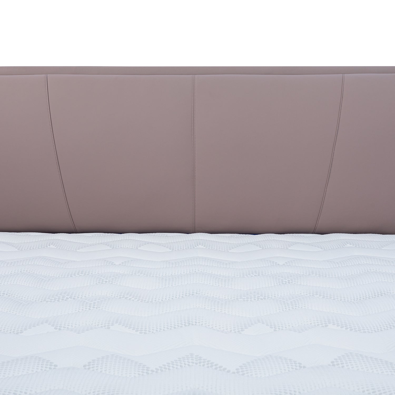 Close-up view of light brown leather bed frame headboard with vertical stitching and white patterned mattress from DeRUCCI.