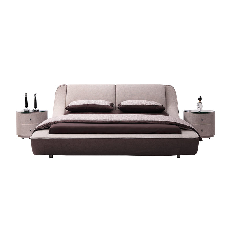 Modern bed frame with padded headboard, accented by dark brown pillows and blanket, flanked by two round nightstands with decorative items. High-quality bedroom furniture from DeRUCCI.