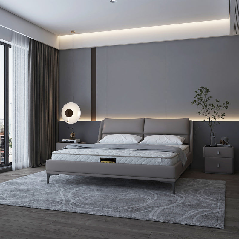 Modern bedroom featuring a gray bed frame and headboard from DeRUCCI, with matching white bedside tables, a round hanging light, and a contemporary gray rug.