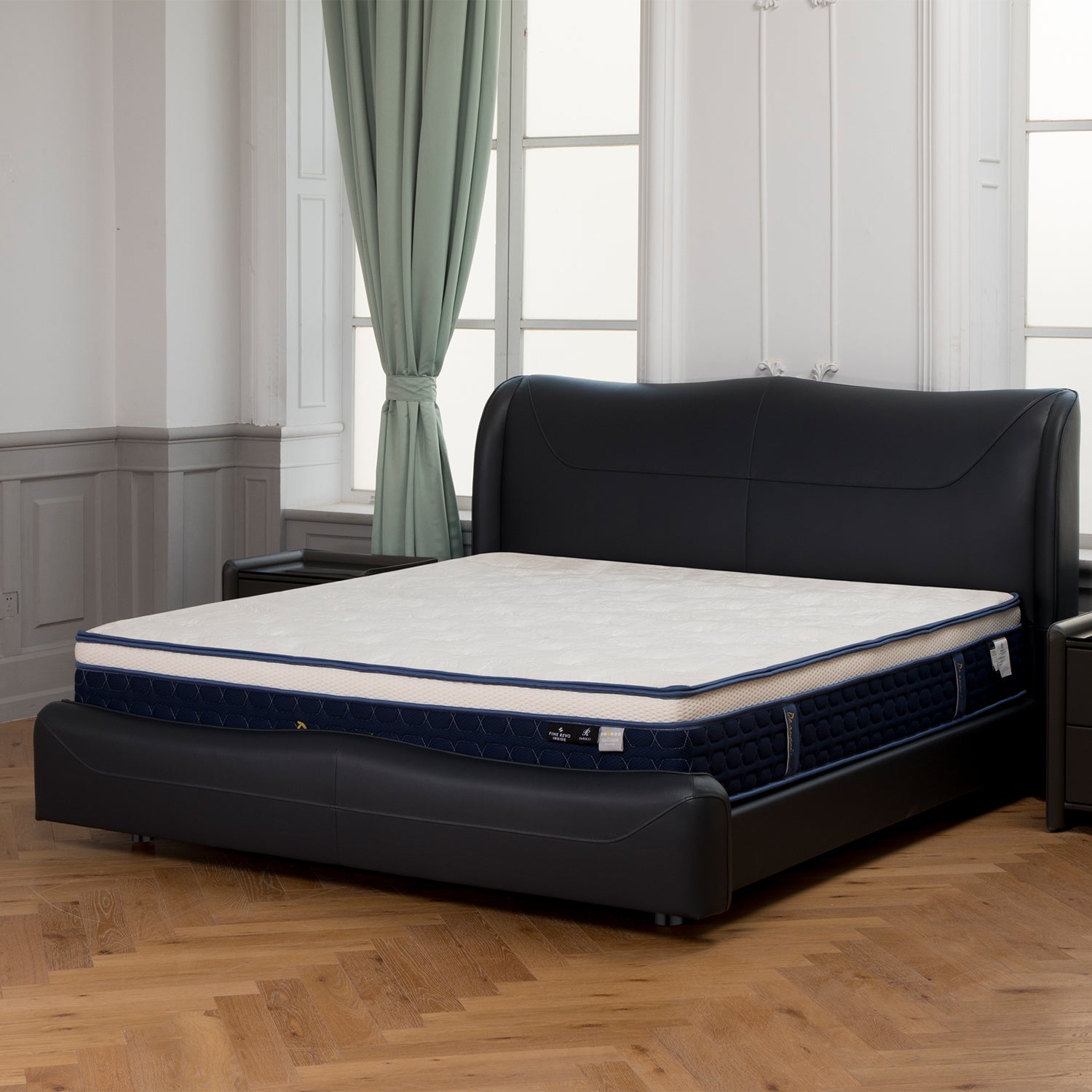 Modern black leather bed frame with padded headboard and deep sea blue bordered mattress in an elegant room with green curtains and wooden flooring.