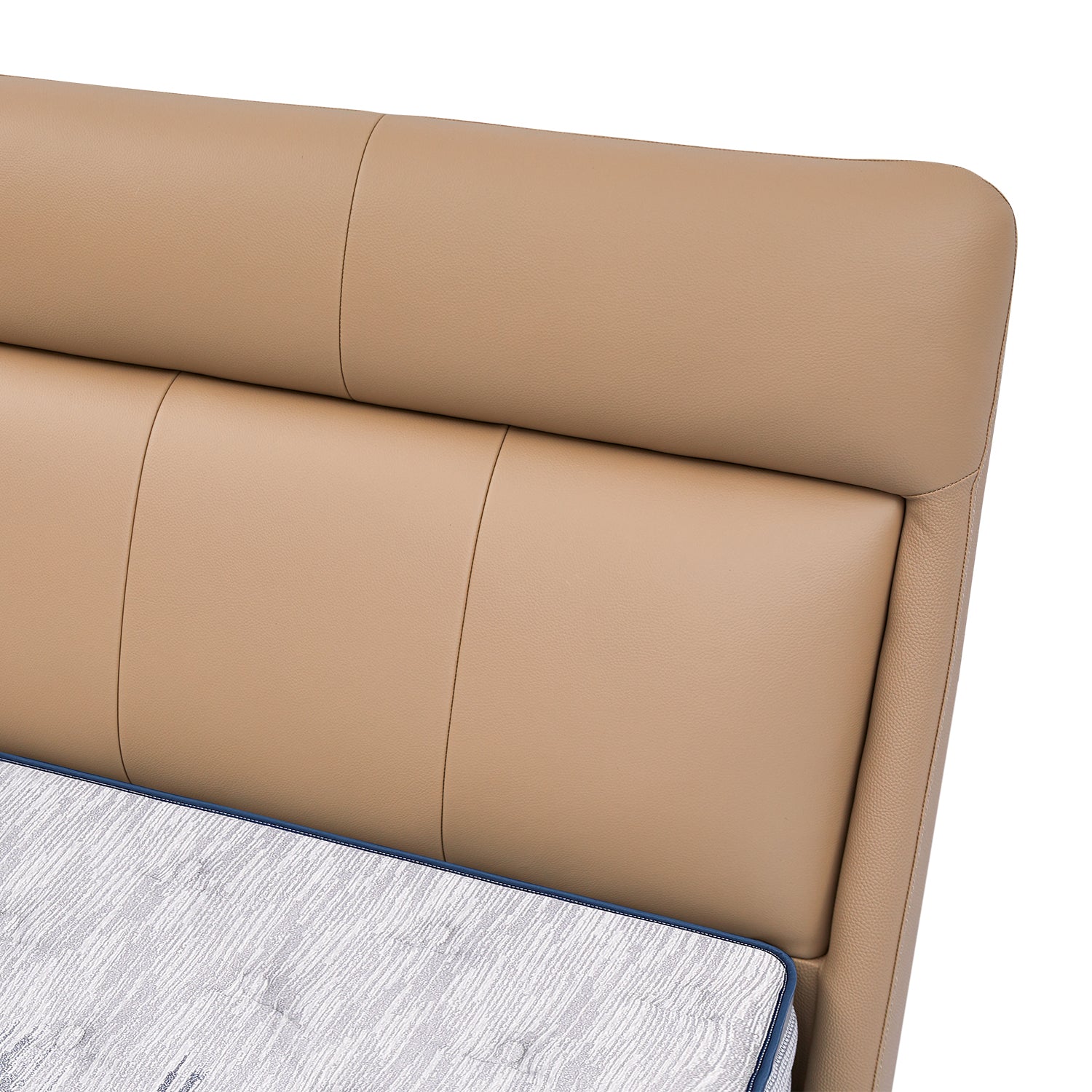 Tan leather bed frame headboard close-up showcasing detailed stitching from DeRUCCI with adjoining mattress.